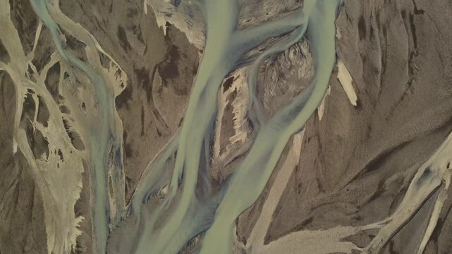 Aerial view of Iceland breathtaking glacial rivers, weaving through the landscape in stunning braided patterns of blue and turquoise meltwater. A natural abstract masterpiece