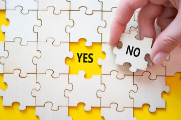 Yes or No symbol. Concept word Yes or No on wooden puzzle. Businessman hand. Beautiful yellow...