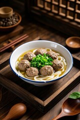 there is a bowl of soup with meatballs and noodles on a wooden tray