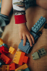 A child is playing with a toy truck made of legos
