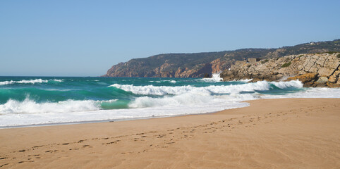 Waves on the empty  beach with mountains and rocks in the background, Guincho beach, Portugal
