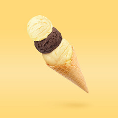 Yummy ice cream served in waffle cone in air on golden background