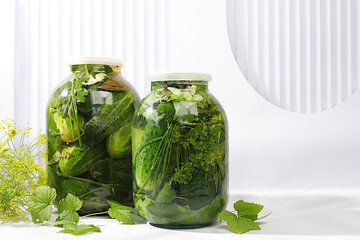 Pickled cucumbers in a jar with garlic and dill on the kitchen table, village harvest, homemade...