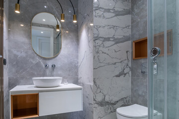 The bathroom is decorated with grey marble tiles, with an elegant design. Stylish decorative...