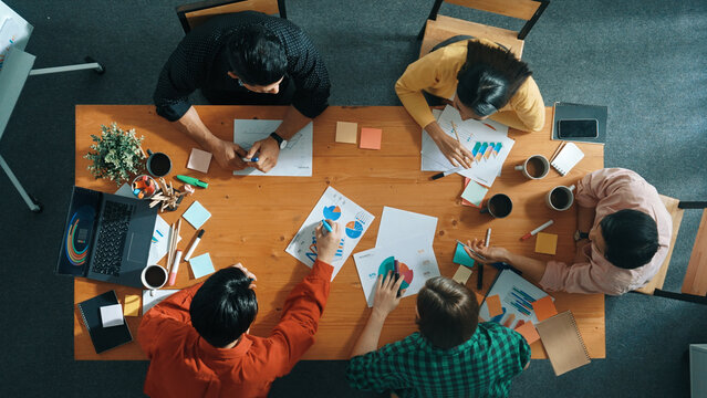 Top down aerial view of business team making scrum task board at meeting room. Group of people writing at paper and sticky notes for making kanban board to manage work flow. Top view. Convocation.