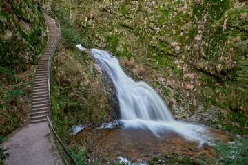 Naklejka premium Majestic Allerheiligen Waterfalls: Powerful Cascades Over Mossy Rocks in Black Forest National Park's Pristine Wilderness
