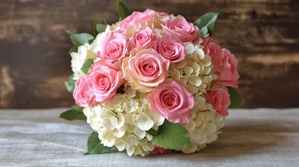 Elegant bouquet of pink roses and white hydrangeas arranged beautifully against a rustic wooden backdrop, perfect for weddings or home decor inspiration.