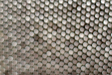 Metallic blurred dots forming regular geometric pattern, creating sophisticated abstract texture...