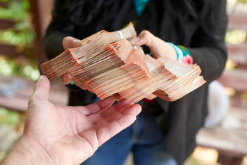 Businesswoman's hands gripping chilean peso banknotes, highlighting professional financial handling and monetary wealth in corporate environment