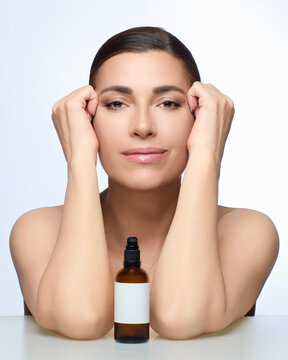 Beautiful natural woman posing with skincare product for beauty and skincare advertisement on white background