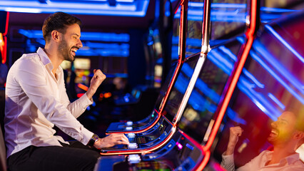 Excited Young Man Winning Big at a Modern Casino Slot Machine