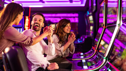 Group of Friends Celebrating Winning at Slot Machines in a Vibrant Casino