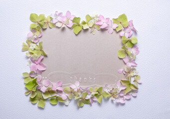 Delicate flat lay floral frame thanks made of soft pink and green petals. Perfect for greeting cards, invitations, or romantic design projects. 