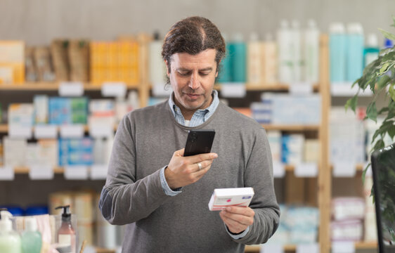 Man scans code on package of paracetamol pills to check the expiration date