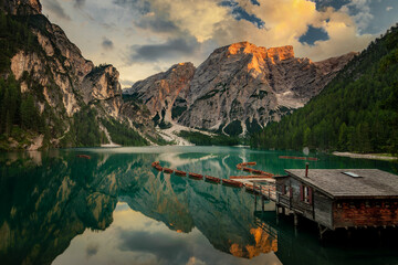 Lago di Braies, Pragser Wildsee. Beautiful sunset with clouds in Dolomites mountains. Epic blue lake, mountain, cliffs, rocks, forest. Premium landscape from pure nature, Dolomiti, Alps, Italy