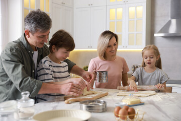 Happy family making dough at white marble table in kitchen