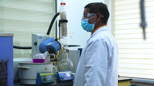 scientist using rotary evaporator. science laboratory hi tech latest machines and equipments in a Science experiment lab for research analysis. fda approved labs. chemists mixing chemicals. scientists
