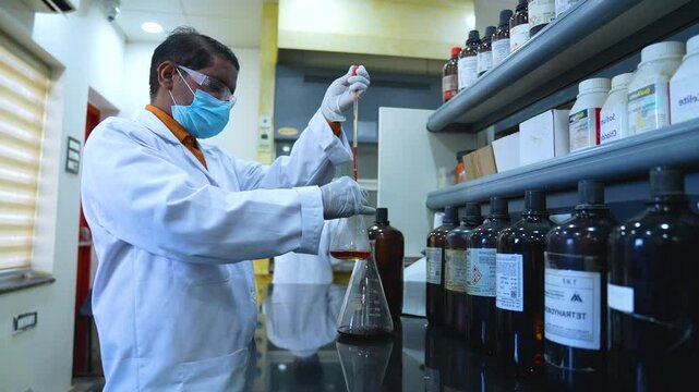 scientist doing experiment with chemicals in a FDA approved laboratory. science laboratory with hplc, spectrometer, gc, uv, ir in background. hi tech latest machines and equipments.