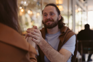 Man sits engaged in conversation at a cozy cafe during the afternoon