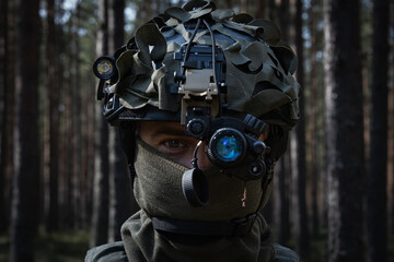 Portrait of a male special operations soldier wearing a tactical helmet with a night vision...