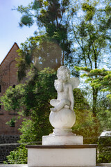 Bargationovsk Kaliningrad region Russia May 15 2022 Angel sculpture against Forburg Castle Preussisch-Eylau in summer