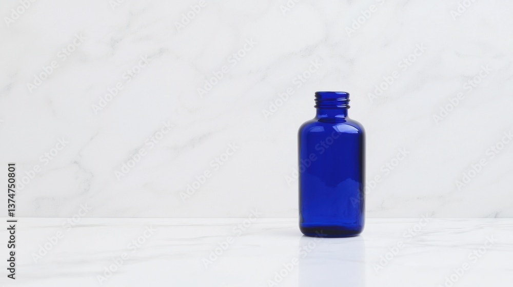 Poster blue glass bottle on a white marble surface. the bottle is cylindrical in shape with a round neck an