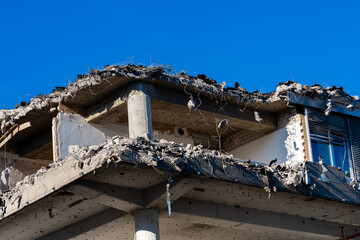 Building partially demolished under clear blue sky at midday