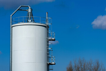 Industrial storage tank against a clear blue sky