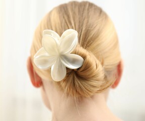 Woman with beautiful hair clip on blurred background, back view