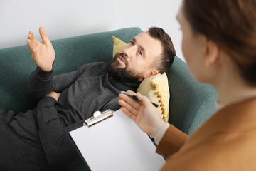 Psychologist working with patient during hypnosis session indoors