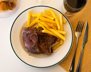 Delicious oven roasted pork cheeks served with side dish of crispy french fries for dinner..