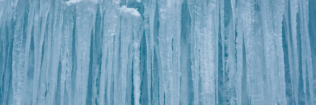 Cold winter icicles melting banner. Blue frozen ice close-up photograph. 	