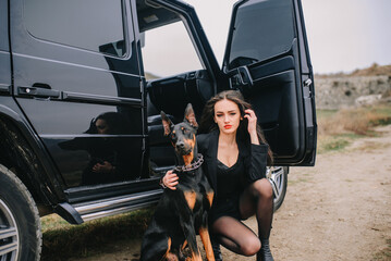 Stylish woman with doberman and luxury suv
