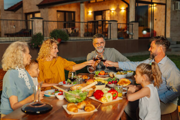 Happy family toasting during a garden party in the evening