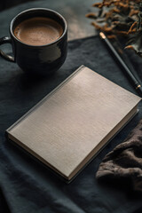 A cozy flat lay featuring an elegant journal, freshly brewed coffee, and natural elements, evoking inspiration and reflection.
