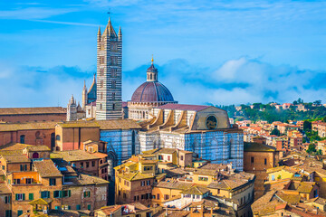 Obraz premium Aerial view of Siena cityscape in the heart of Tuscany, showcasing its intricate Gothic architecture, towering bell tower, and striped marble facade, surrounded by the terracotta rooftops