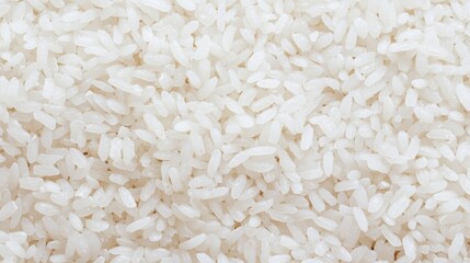 Close-up of a pile of white rice grains. the grains are small and irregularly shaped, with some grains overlapping each other.