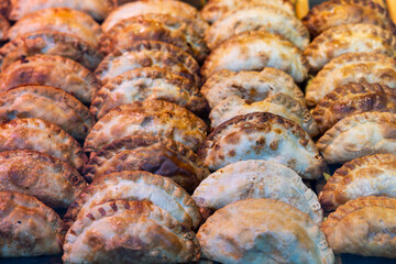Delicious empanadas lined up in rows in a store window
