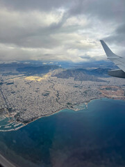 AERIAL: View from an airplane window during a flight above Athens, a sprawling city that stretches...