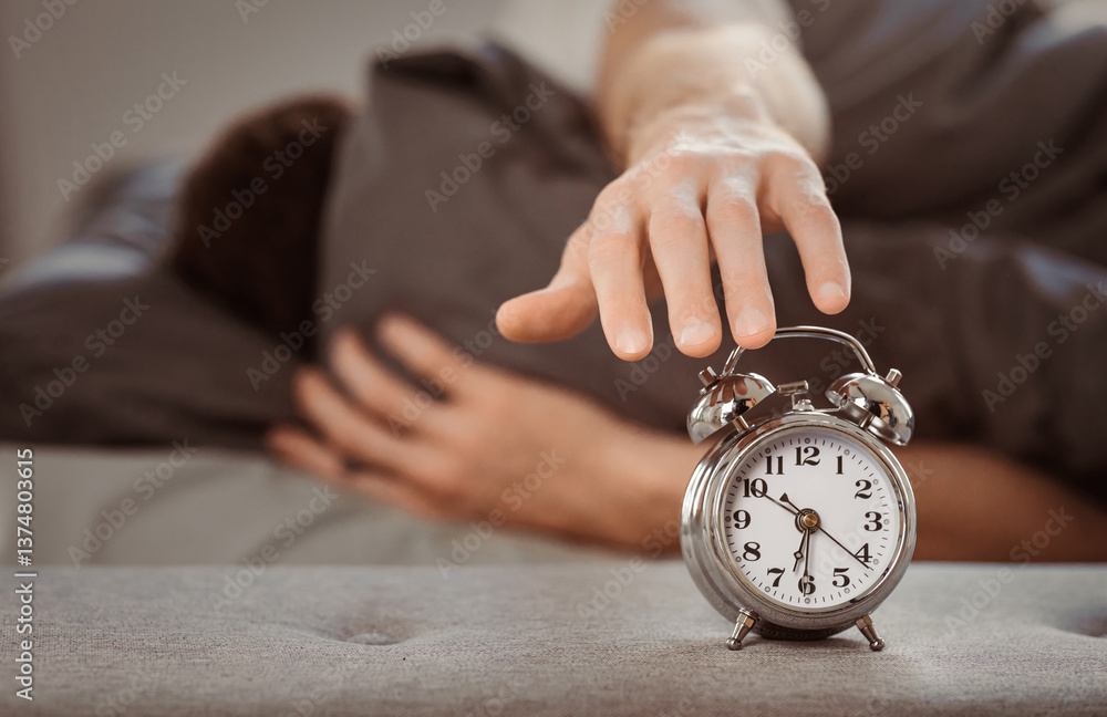 Aufkleber time to get up. man turning off alarm-clock waking up wrapped in blanket lying in bed at home. shall