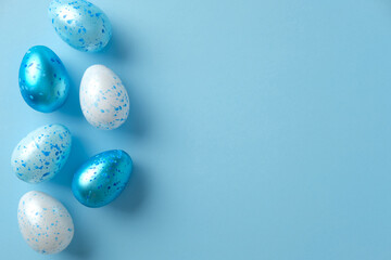 Blue and white speckled eggs on a pastel blue background. Perfect for Easter, spring decor, and creative holiday design