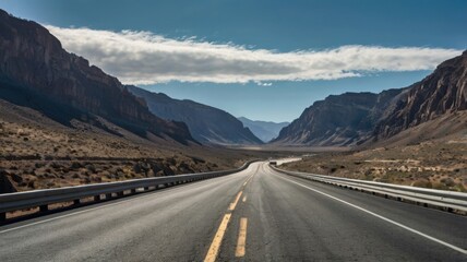An empty highway stretching through a rugged mountain landscape, steep cliffs on either side, deep blue sky and distant peaks in the background