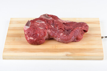 Uncooked raw beef meat on wooden cutting board.