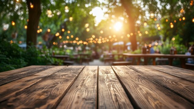 Empty wooden table outdoors at a garden restaurant at sunset