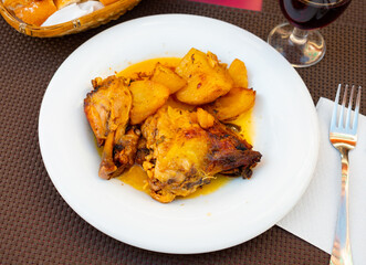 Closeup of homemade baked chicken legs with potatoes on plate