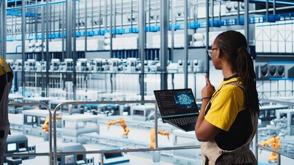Engineer in smart factory using augmented reality to collect data on laptop. Professional on...
