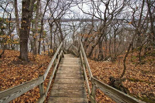 Early Spring landscape of wooden steps leading down to the Illinois River on a partly cloudy day at Starved Rock State Park near Oglesby, Illinois.