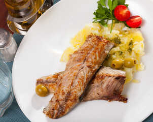 Delicious fried mackerel fillets with mashed potatoes, olives and tomatoes
