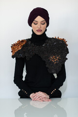 A stylish Muslim woman in a hijab presents her innovative handmade fashion accessory crafted from...