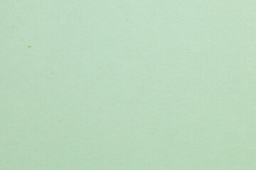 A green background with a white object in the middle, textured origami paper backdrop